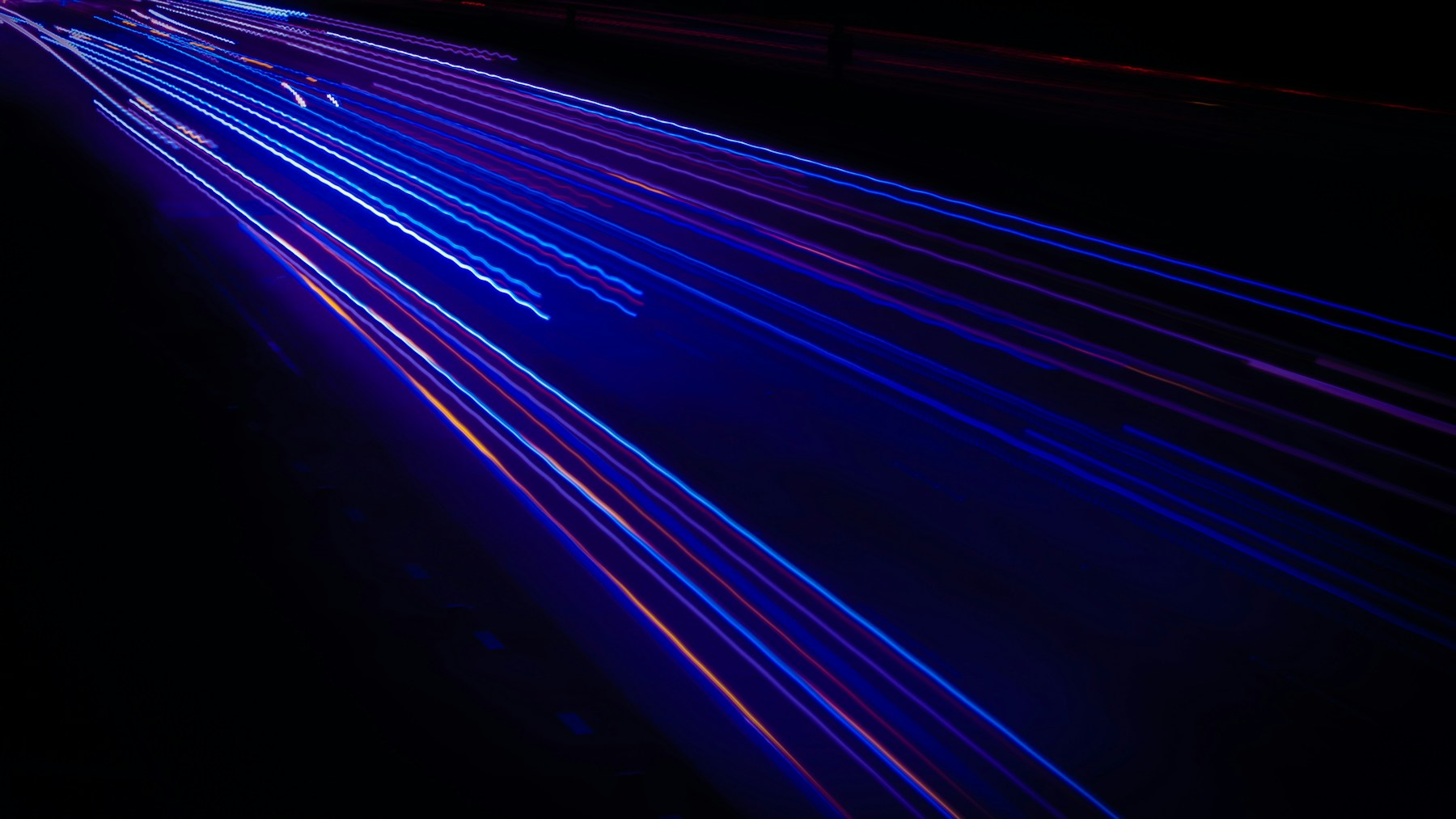 Blue and violet light trails converging across a dark background.